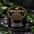 Woody's for Men Headwax 2 oz black and gold jar on dark stone with green leaves