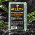 Woody's Moisturizing Bar 8 oz on wet stone with green leaves
